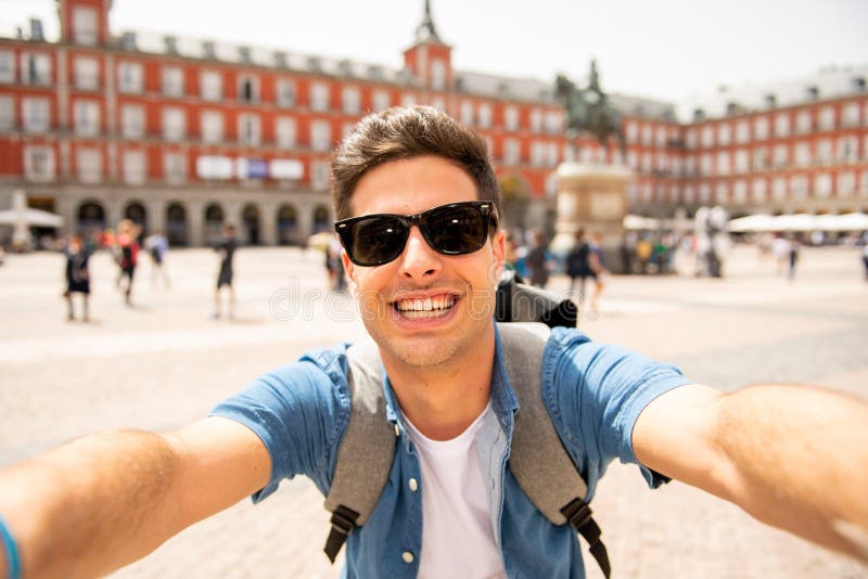 Hombre turístico caucásico joven hermoso feliz y emocionado tomando un selfie en alcalde de la plaza, Madrid España