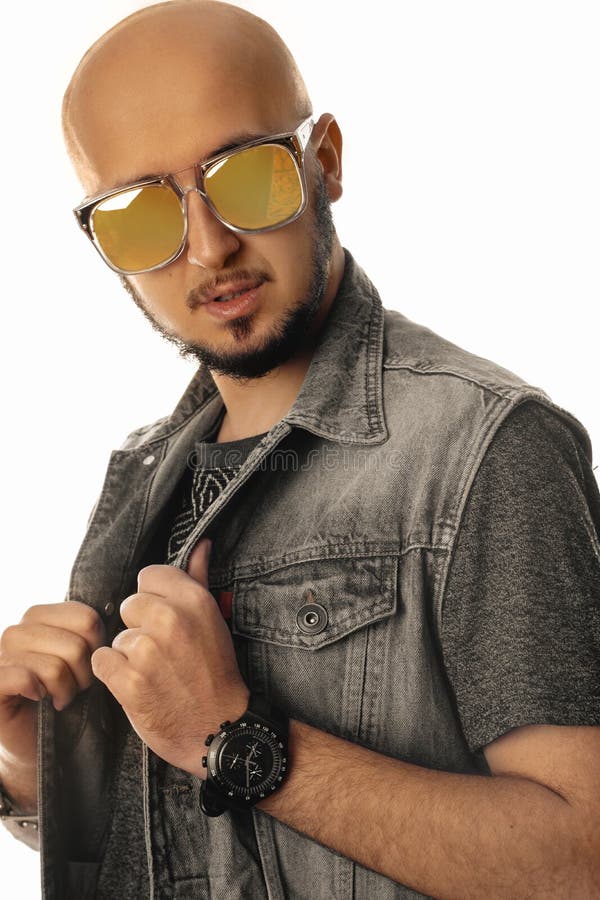 Hombre unshaved hermoso en las gafas de sol que miran la cámara aislada en el fondo blanco en estudio