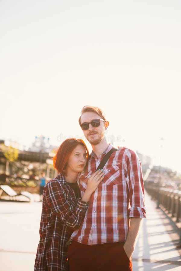 Hombre y mujer en la camisa de tela escocesa que abraza en el fondo de la ciudad fotos de archivo libres de regalías Hombre y mujer en la camisa de tela escocesa que abraza en el fondo de la ciudad fotos de archivo libres de regalías