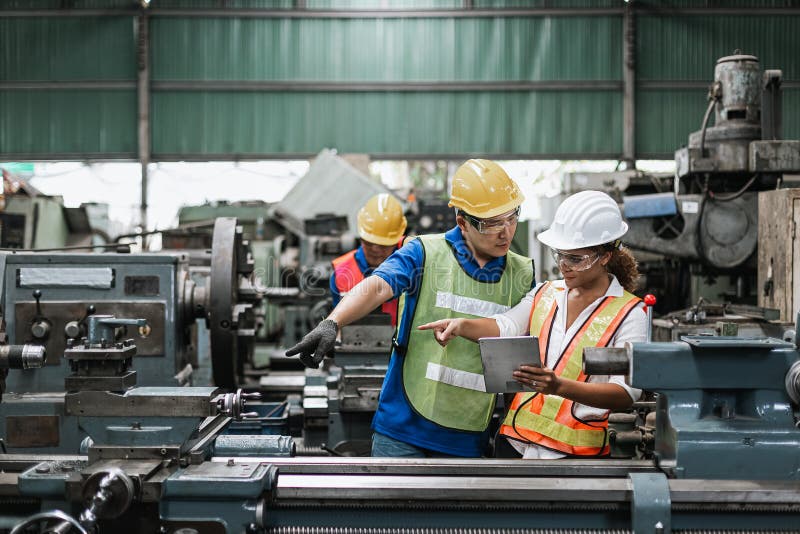 Hombre y mujer ingeniero industrial trabajador usando sombrero duro en fábrica.