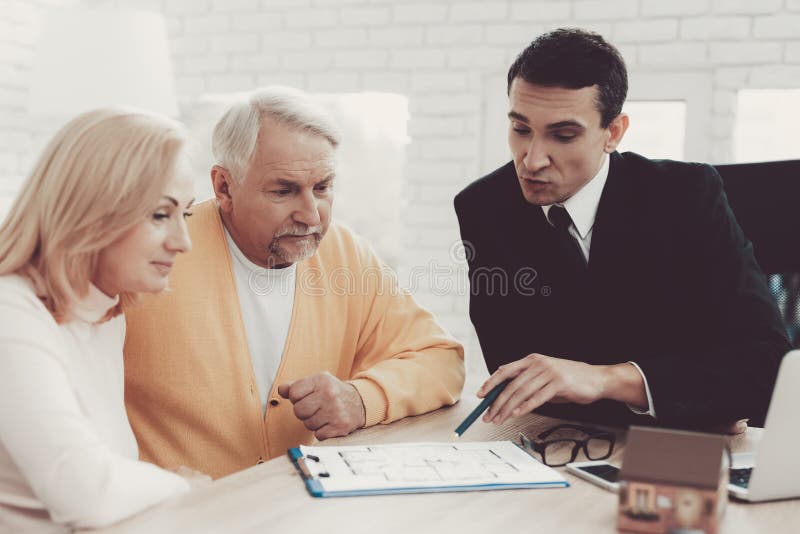 Hombre y mujer que consultan con agente inmobiliario en oficina imagen de archivo libre de regalías