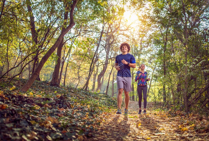 Hombre y mujer que corren en la aptitud de la naturaleza, deporte, entrenamiento imagen de archivo libre de regalías Hombre y mujer que corren en la aptitud de la naturaleza, deporte, entrenamiento imagen de archivo libre de regalías