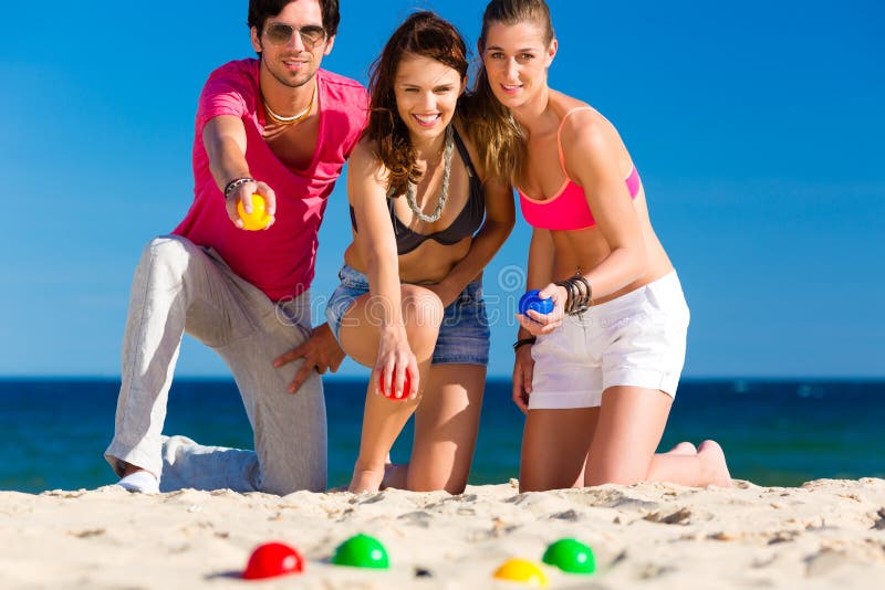 Hombre y mujeres que juegan boule en la playa foto de archivo Hombre y mujeres que juegan boule en la playa foto de archivo