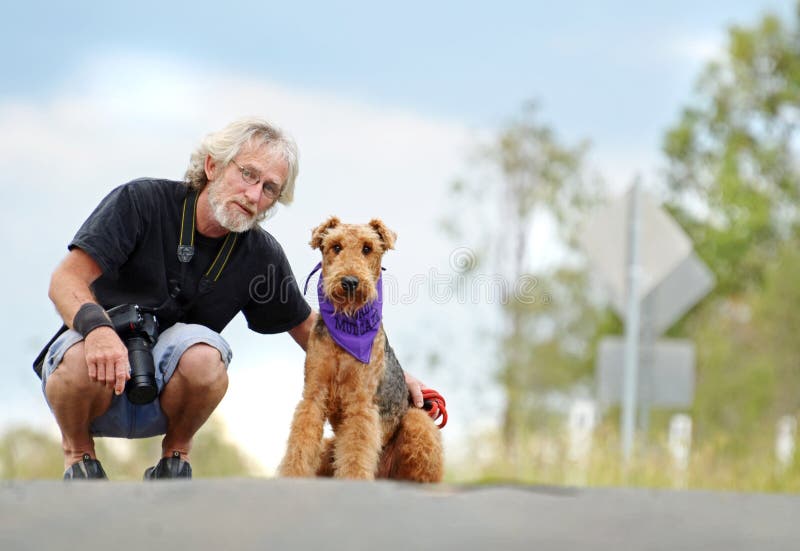 Hombre y perro casero maduros mayores en paseo al aire libre imagen de archivo libre de regalías Hombre y perro casero maduros mayores en paseo al aire libre imagen de archivo libre de regalías
