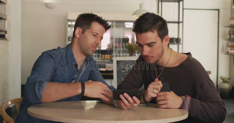 Hombres caucásicos pasan tiempo juntos en un café almacen de metraje de vídeo