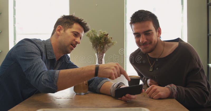 Hombres caucásicos pasan tiempo juntos en un café metrajes
