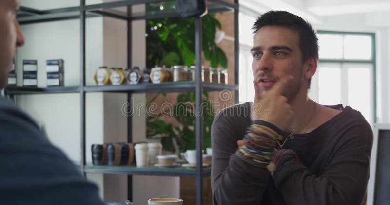 Hombres caucásicos pasan tiempo juntos en un café metrajes