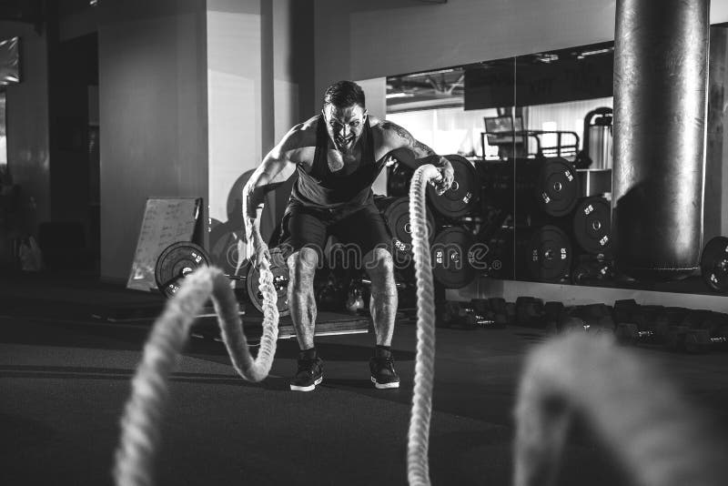 Hombres con la cuerda en gimnasio funcional del entrenamiento foto de archivo libre de regalías Hombres con la cuerda en gimnasio funcional del entrenamiento foto de archivo libre de regalías