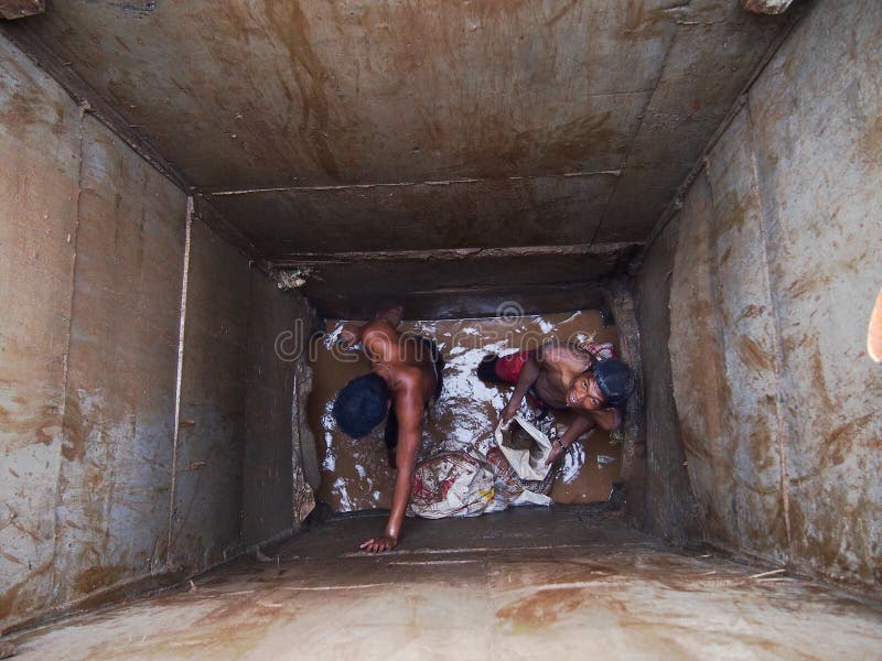 Hombres de la construcción que trabajan dentro de un alcantarillado del camino fotos de archivo Hombres de la construcción que trabajan dentro de un alcantarillado del camino fotos de archivo