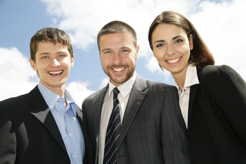 Young and successful businesspeople stand against the blue sky. Young and successful businesspeople stand against the blue sky