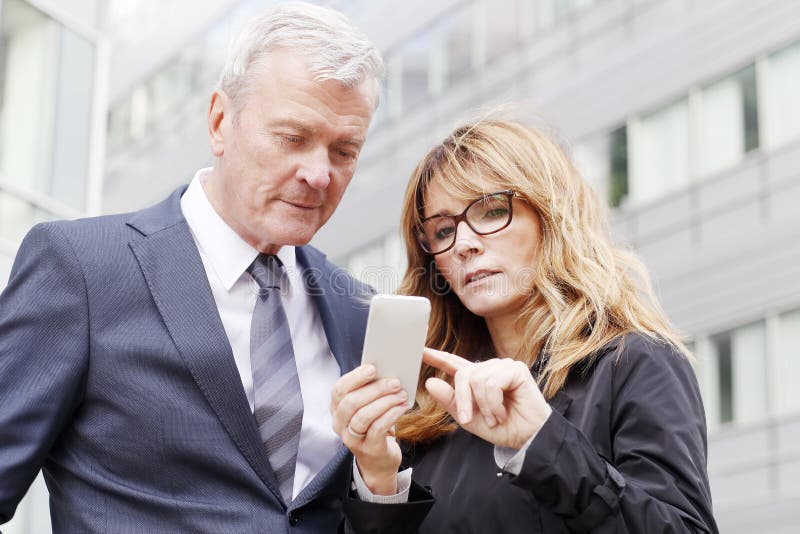 Hombres de negocios con el teléfono móvil fotos de archivo libres de regalías Hombres de negocios con el teléfono móvil fotos de archivo libres de regalías