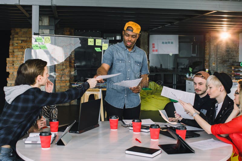 Hombres de negocios jovenes del grupo recolectados junto discutiendo idea creativa Grupo de estudiantes internacionales que se si imágenes de archivo libres de regalías Hombres de negocios jovenes del grupo recolectados junto discutiendo idea creativa Grupo de estudiantes internacionales que se si imágenes de archivo libres de regalías