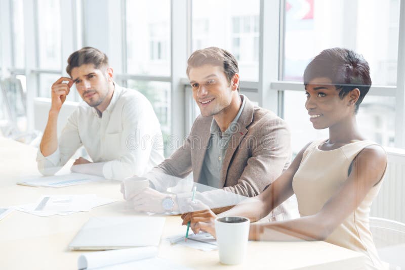 Hombres de negocios que se sientan en el entrenamiento y que hacen notas en oficina imagen de archivo libre de regalías Hombres de negocios que se sientan en el entrenamiento y que hacen notas en oficina imagen de archivo libre de regalías