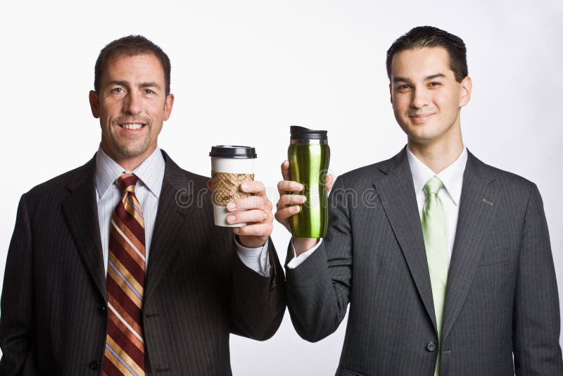 Hombres de negocios que sostienen las tazas de café fotos de archivo libres de regalías Hombres de negocios que sostienen las tazas de café fotos de archivo libres de regalías