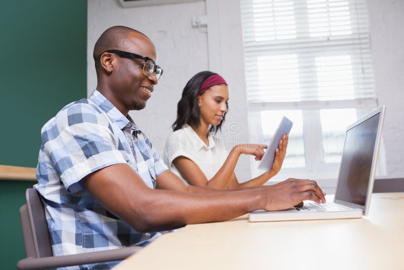 Hombres de negocios que trabajan en un ordenador portátil y una tableta imagenes de archivo Hombres de negocios que trabajan en un ordenador portátil y una tableta imagenes de archivo