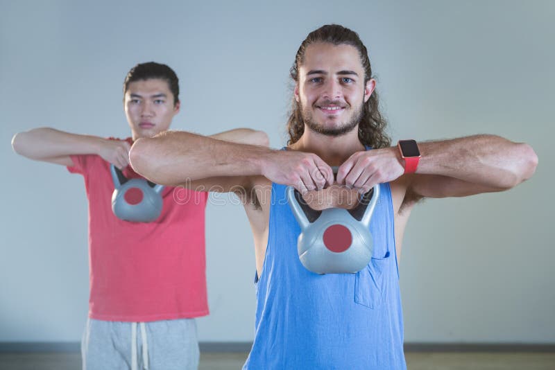 Hombres que ejercitan con el kettlebell imagen de archivo libre de regalías Hombres que ejercitan con el kettlebell imagen de archivo libre de regalías
