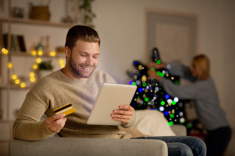Hombres sonrientes guapos haciendo compras en línea en Navidad fotografía de archivo libre de regalías