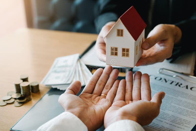 Home agents are giving house gifts to new home buyers in office room.