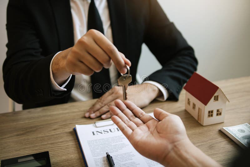 Home agents are handing out keys to home buyers who are signing contracts at the office royalty free stock photography Home agents are handing out keys to home buyers who are signing contracts at the office royalty free stock photography