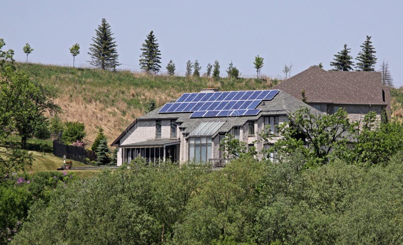 A house outfitted with solar panels, surrounded by trees. A house outfitted with solar panels, surrounded by trees.