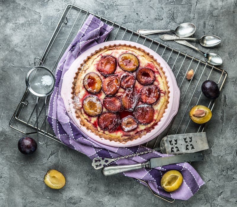 Homemade plum pie on a concrete background top view