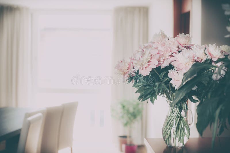 Home decoration with fresh pink peonies bunch in glass vase at living room background, Nostalgic retro royalty free stock photography Home decoration with fresh pink peonies bunch in glass vase at living room background, Nostalgic retro royalty free stock photography