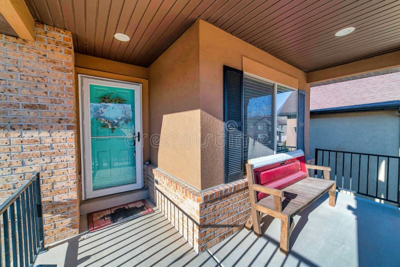 Home entrance with storm door wooden front door open porch and brick wall