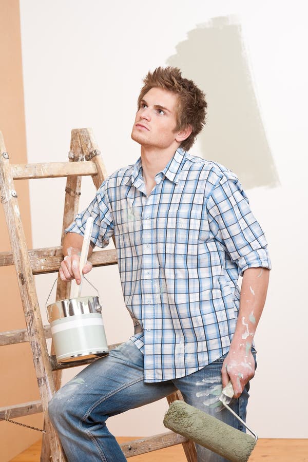 Home improvement: Young man with paint roller royalty free stock photography