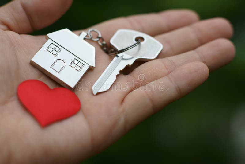 Home key with love house keyring and red mini heart on hand, sweet home giving, concept