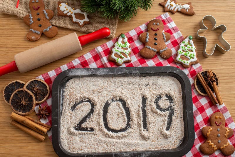 Home made Christmas gingerbread cookies with 2019 written on flour royalty free stock photography Home made Christmas gingerbread cookies with 2019 written on flour royalty free stock photography