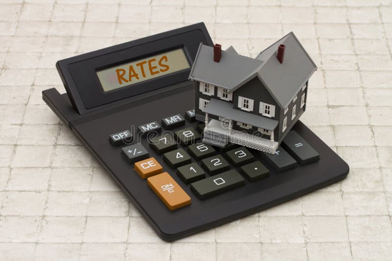 Home Mortgage Interest Rates, A gray house and calculator on stone background with text Rates