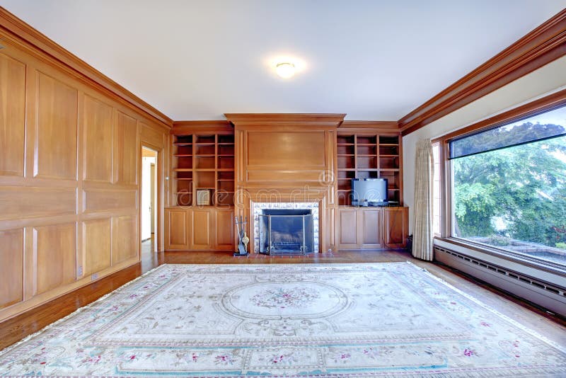 Home office with fireplace and wood walls in luxury old Ameican house.