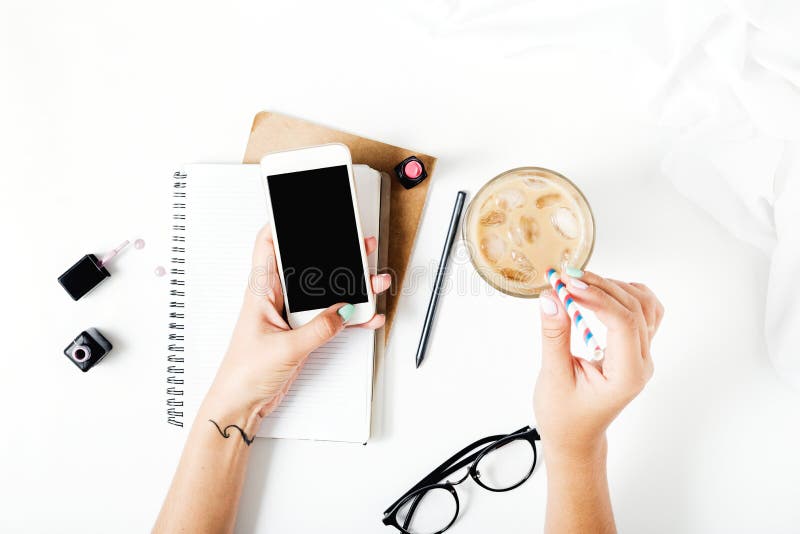 Home office workspace with smartphone in female hands. Flat lay