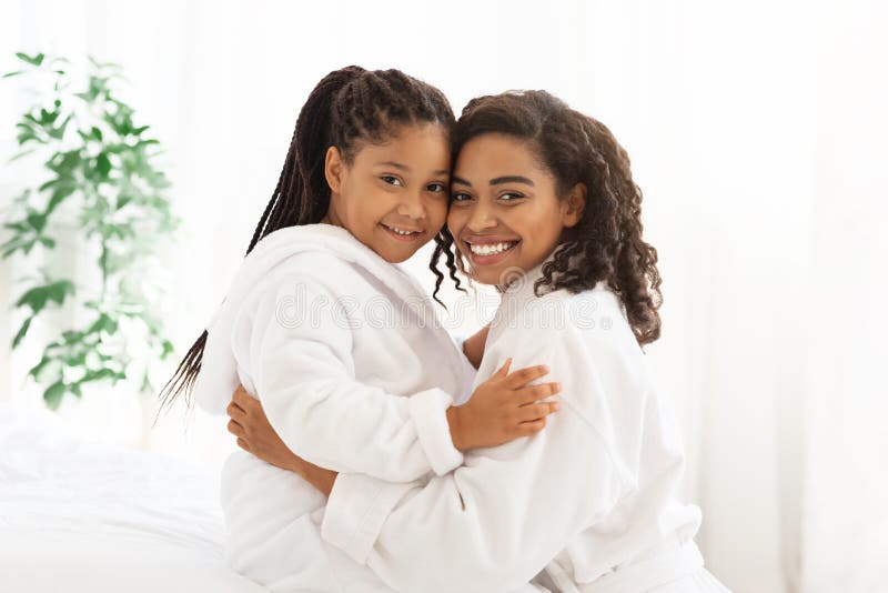 Home Portrait Of Happy Loving Black Family Mother And Daughter In Bathrobes