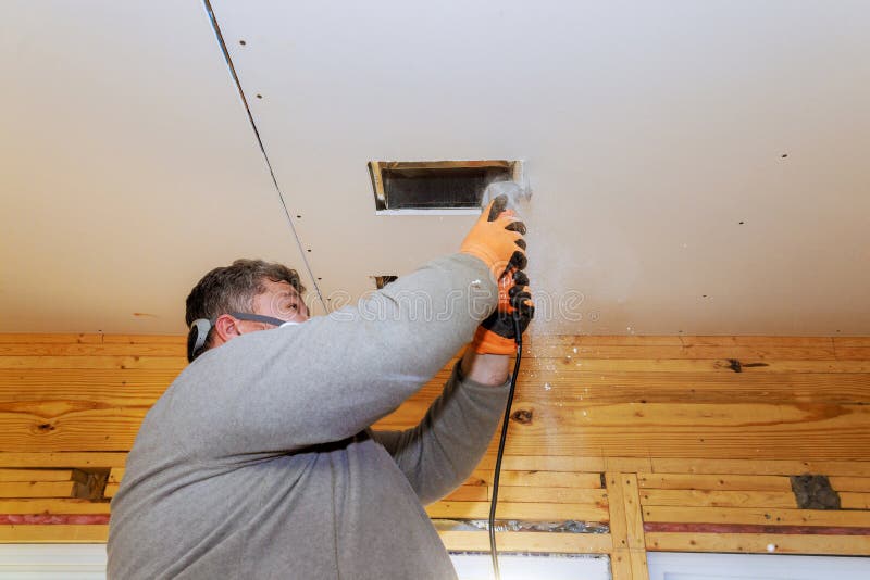 Home renovation project in progress with a contractor repairing a ceiling vent royalty free stock image