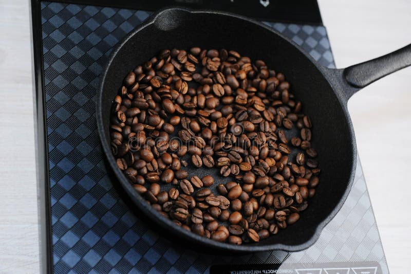 Home Roast Coffee in a Cast Iron Pan. Induction Cooker Top View Stock