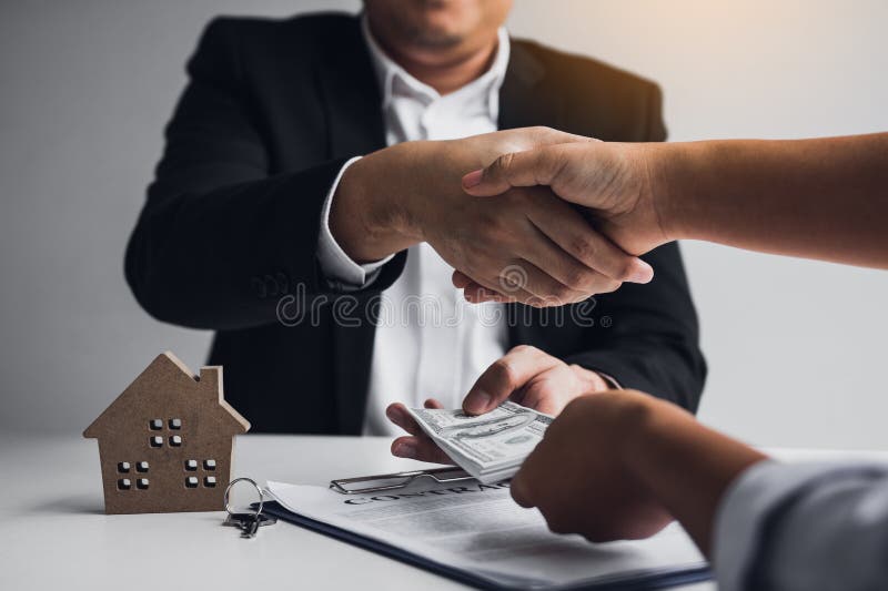 Home sales agents and buyers work on signing new homes and shaking hands royalty free stock photo Home sales agents and buyers work on signing new homes and shaking hands royalty free stock photo