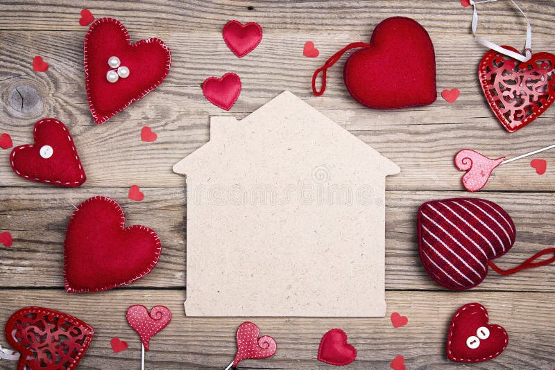 Home symbol with red hearts on wooden background with copy space. Home sweet home.