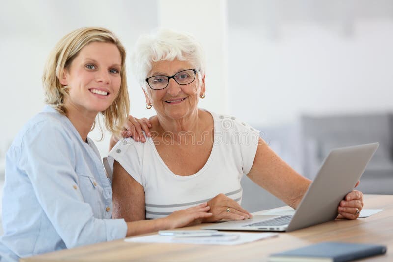 Homecarer with elderly women using laptop computer. Homecarer with elderly women using laptop computer