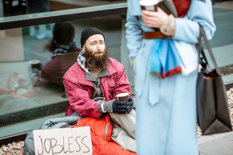 Homeless begging money to a passing by woman