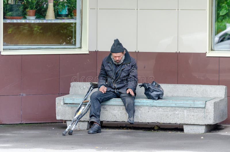 Homeless, legless man resting on a bench.
