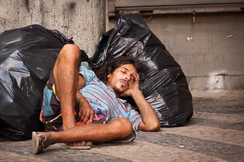 Homeless man sleeping on plastic bags.