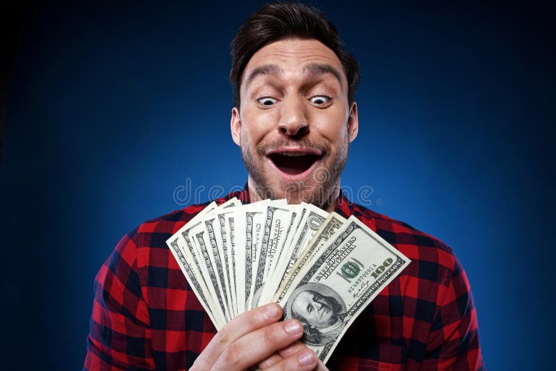 Homem afortunado que guarda o dinheiro de 100 notas de dólar em sua mão fotos de stock Homem afortunado que guarda o dinheiro de 100 notas de dólar em sua mão fotos de stock