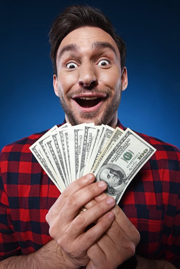 Homem afortunado que guarda o dinheiro de 100 notas de dólar em sua mão fotografia de stock royalty free Homem afortunado que guarda o dinheiro de 100 notas de dólar em sua mão fotografia de stock royalty free
