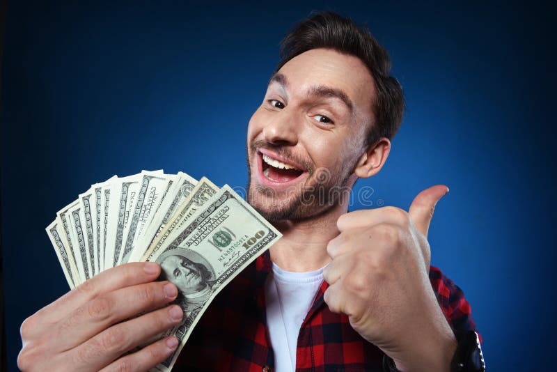 Homem afortunado que guarda o dinheiro de 100 notas de dólar em sua mão fotos de stock Homem afortunado que guarda o dinheiro de 100 notas de dólar em sua mão fotos de stock