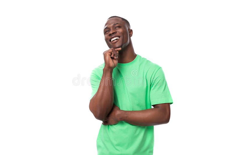 30 years old smart successful african man dressed in a light green t-shirt on an isolated white studio background. 30 years old smart successful african man dressed in a light green t-shirt on an isolated white studio background.