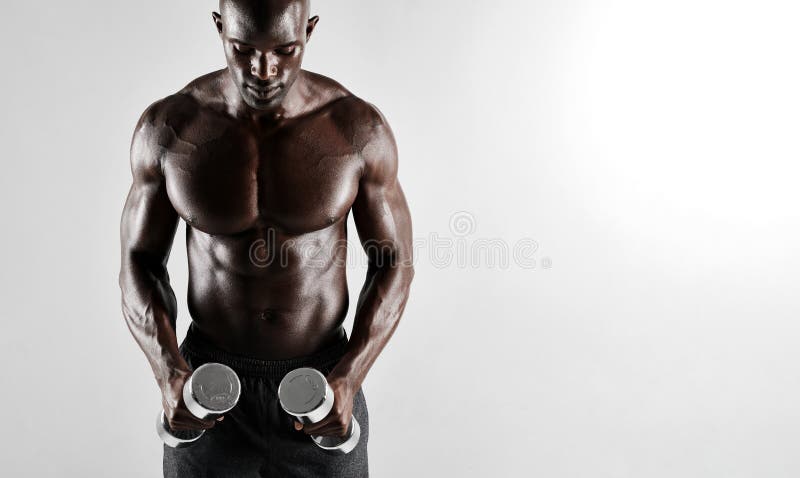 Homem africano muscular que exercita com pesos fotografia de stock Homem africano muscular que exercita com pesos fotografia de stock