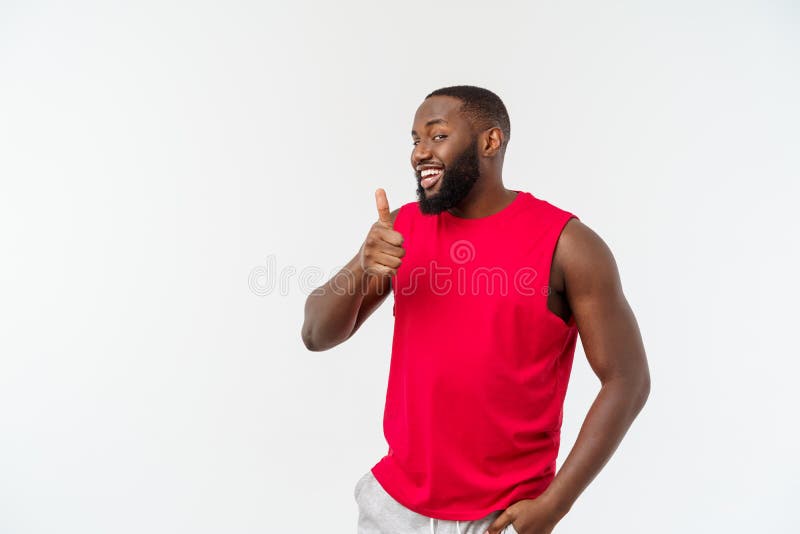 Young african american man over  background wearing sport wear smiling with happy face looking with thumb up. Young african american man over  background wearing sport wear smiling with happy face looking with thumb up