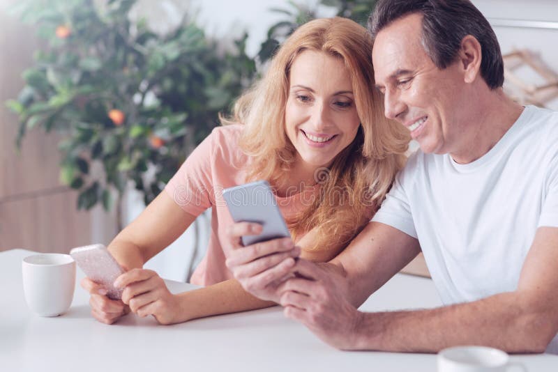 Homem alegre feliz que senta-se junto com sua esposa fotografia de stock Homem alegre feliz que senta-se junto com sua esposa fotografia de stock