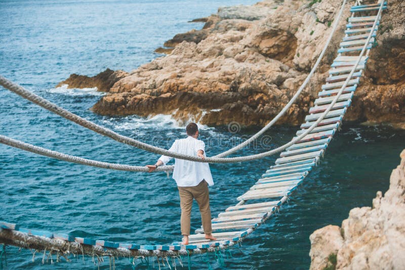 Homem Andando Pela Ponte Suspensa Atravessando a Baía Do Mar Foto de Stock  - Imagem de caucasiano, foto: 224509932